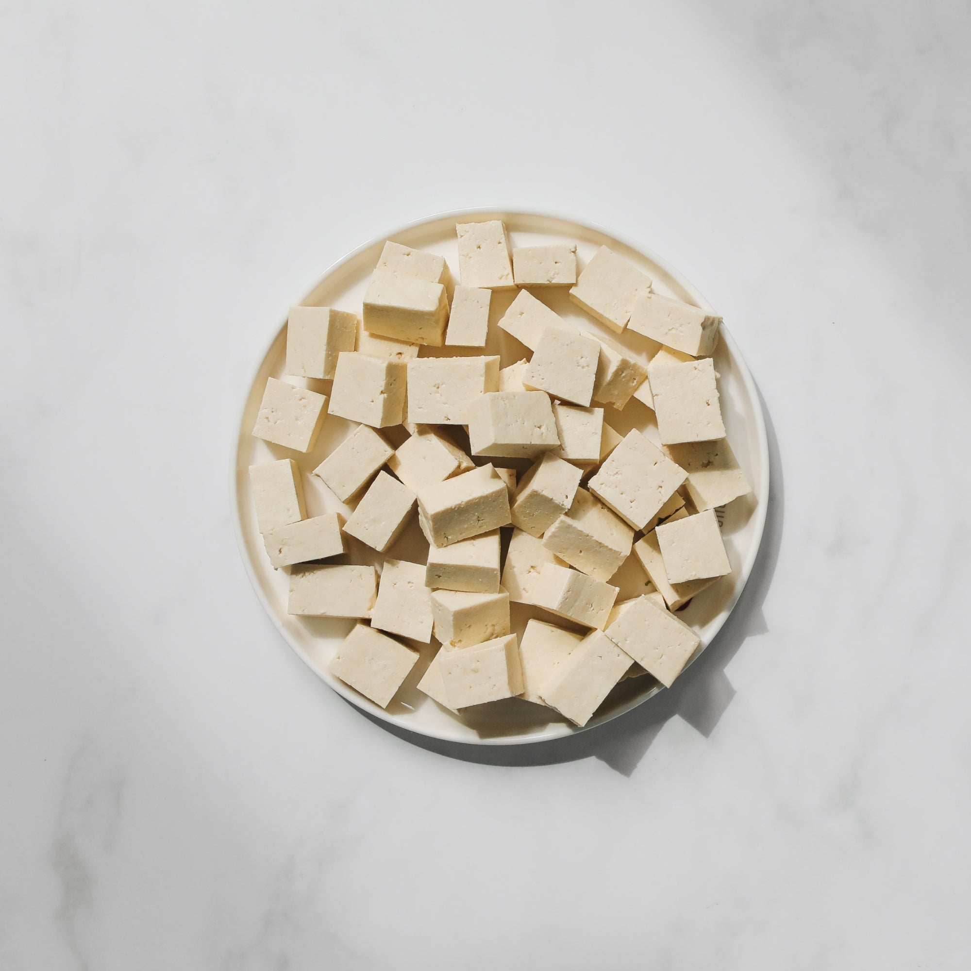 Tofu in a bowl on a marble countertop